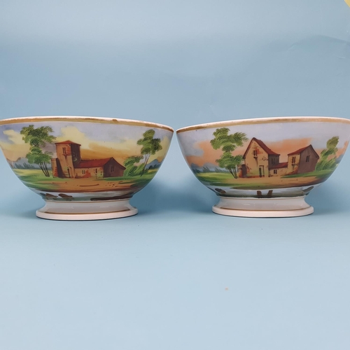 242 - A pair of late 19th century porcelain bowls, decorated figures and dwellings, 20.5 cm diameter (2), ... 