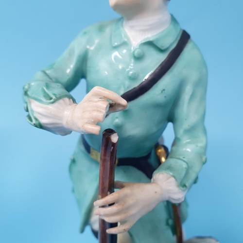 255 - A 19th century porcelain figure, of a hunter with a rifle, 18 cm high, and another Dresden figure of... 