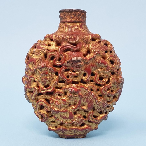 287 - A Chinese lacquered snuff bottle, decorated Dogs of Fo and mythical beasts, 7 cm high