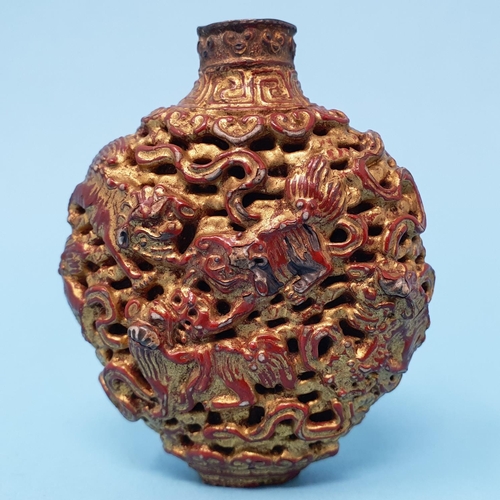 287 - A Chinese lacquered snuff bottle, decorated Dogs of Fo and mythical beasts, 7 cm high