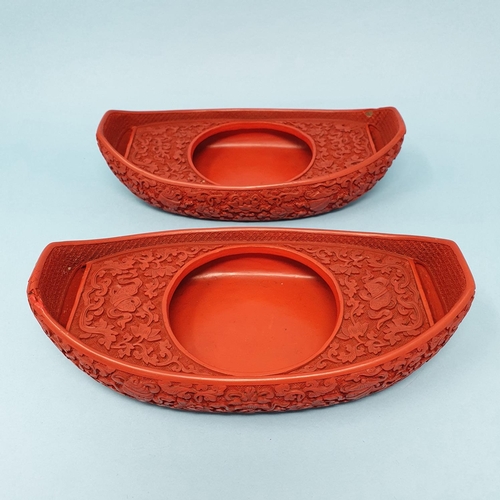 299 - A pair of Chinese red cinnabar lacquer stands, of shoe form, 19 cm wide, removal cost A