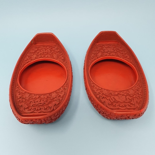 299 - A pair of Chinese red cinnabar lacquer stands, of shoe form, 19 cm wide, removal cost A