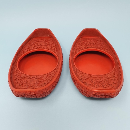 299 - A pair of Chinese red cinnabar lacquer stands, of shoe form, 19 cm wide, removal cost A