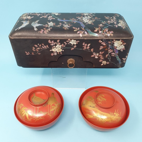 305 - A Japanese lacquered box, 29 cm wide and a pair of Japanese red lacquered bowl and covers, 13 cm dia... 