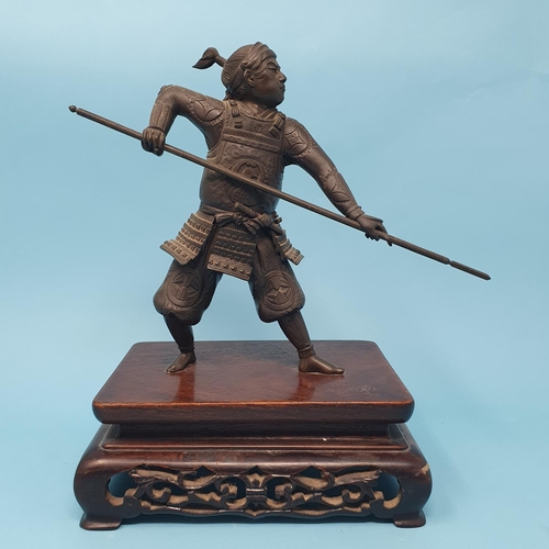 314 - A Japanese bronze Samurai, holding a katana, on a carved and pierced hardwood stand, Meiji period, 2... 