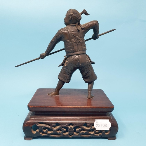 314 - A Japanese bronze Samurai, holding a katana, on a carved and pierced hardwood stand, Meiji period, 2... 