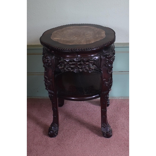 318 - A Chinese hardwood two tier jardiniere stand, of shaped circular form, with a marble inset top, abov... 