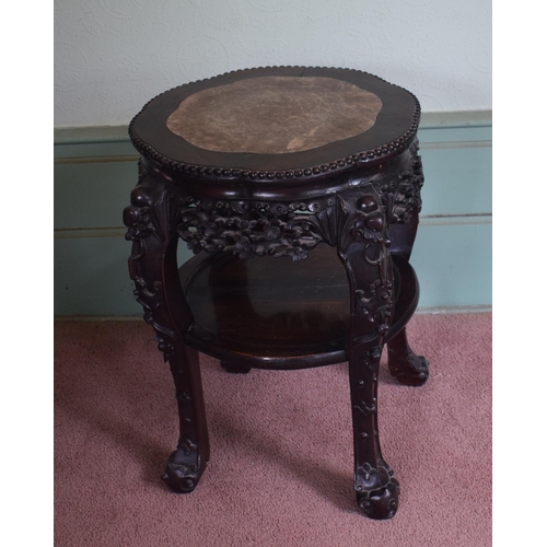 318 - A Chinese hardwood two tier jardiniere stand, of shaped circular form, with a marble inset top, abov... 