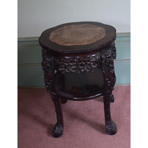 318 - A Chinese hardwood two tier jardiniere stand, of shaped circular form, with a marble inset top, abov... 