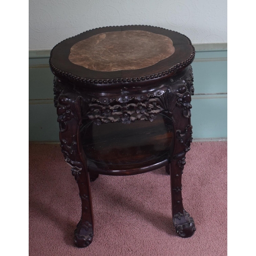 318 - A Chinese hardwood two tier jardiniere stand, of shaped circular form, with a marble inset top, abov... 