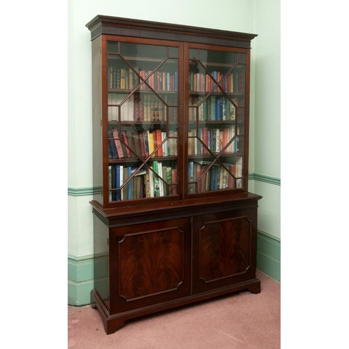 320 - A 19th century bookcase on cupboard, the moulded dentil cornice above a fluted frieze, with a pair o... 