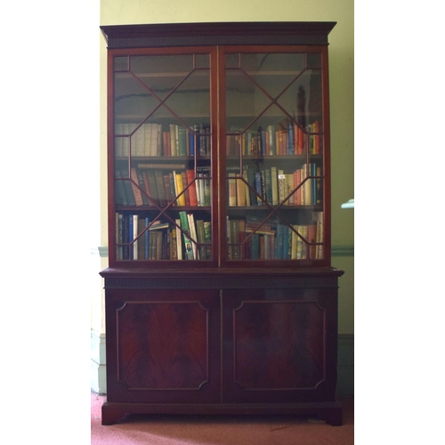 320 - A 19th century bookcase on cupboard, the moulded dentil cornice above a fluted frieze, with a pair o... 