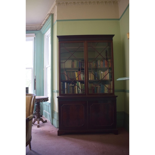 320 - A 19th century bookcase on cupboard, the moulded dentil cornice above a fluted frieze, with a pair o... 