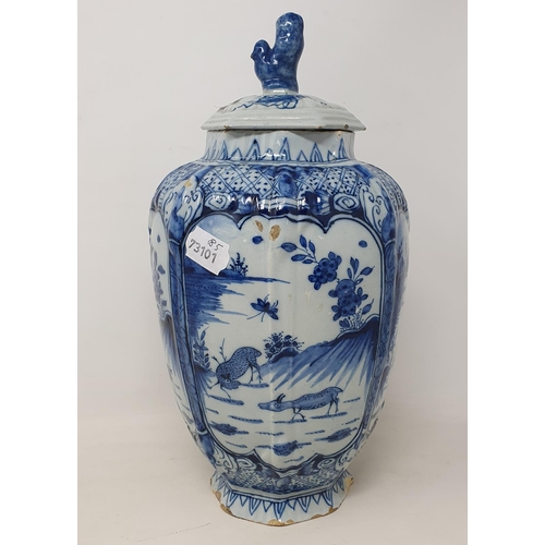 351 - A 19th century Dutch Delft vase and associated cover, of octagonal baluster form, decorated deer, in... 