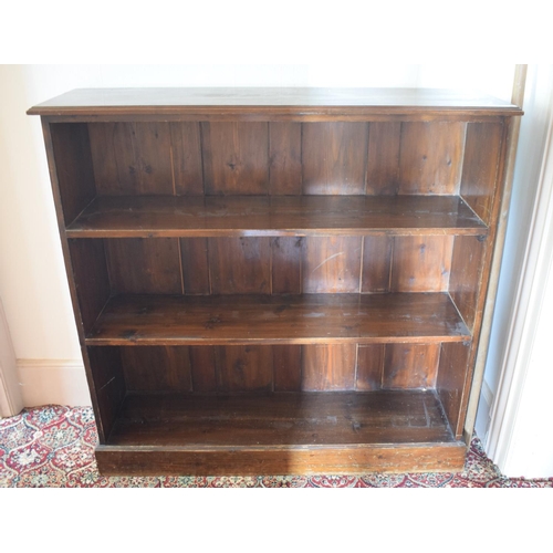 60 - A stained pine open bookcase, on a plinth base, 122 cm wide, removal cost C