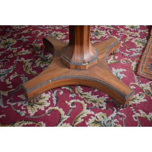 107 - An early Victorian rosewood centre table, the tilt top on an octagonal column and concave sided plat... 