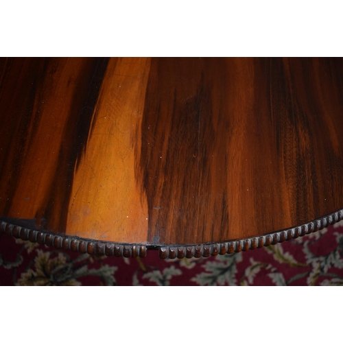 107 - An early Victorian rosewood centre table, the tilt top on an octagonal column and concave sided plat... 