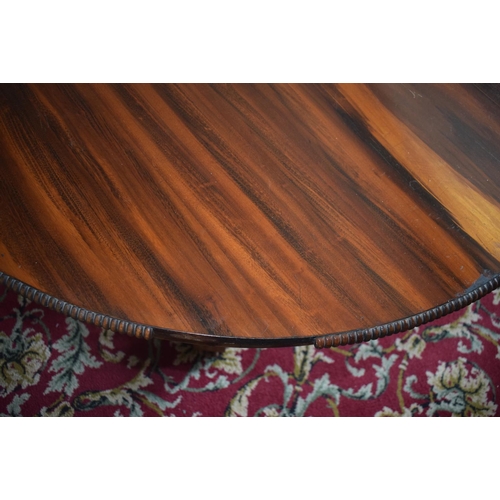 107 - An early Victorian rosewood centre table, the tilt top on an octagonal column and concave sided plat... 