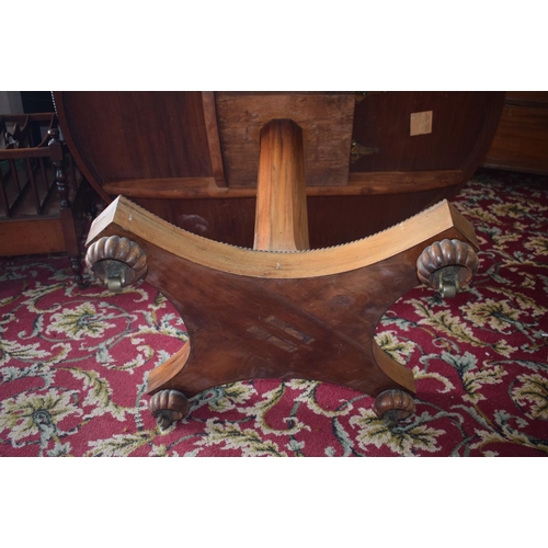 107 - An early Victorian rosewood centre table, the tilt top on an octagonal column and concave sided plat... 