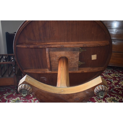 107 - An early Victorian rosewood centre table, the tilt top on an octagonal column and concave sided plat... 