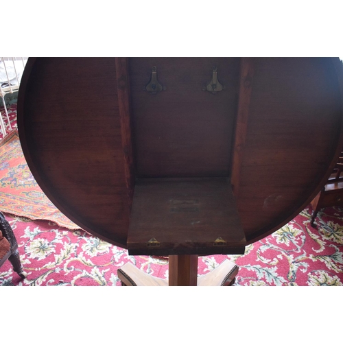 107 - An early Victorian rosewood centre table, the tilt top on an octagonal column and concave sided plat... 