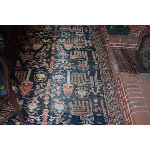 174 - A large carpet, with floral and geometric motifs on a blue ground, within a multi border, worn, fade... 