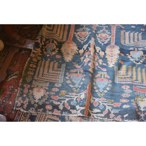 174 - A large carpet, with floral and geometric motifs on a blue ground, within a multi border, worn, fade... 