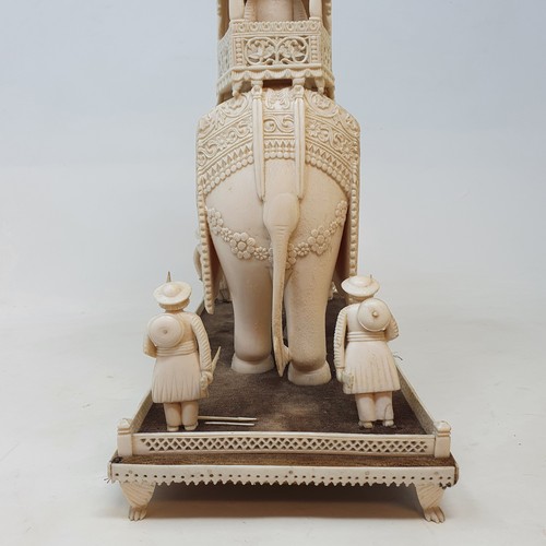 295 - A late 19th century carved ivory elephant, carrying a howdah, carrying two figures escorted by four ... 