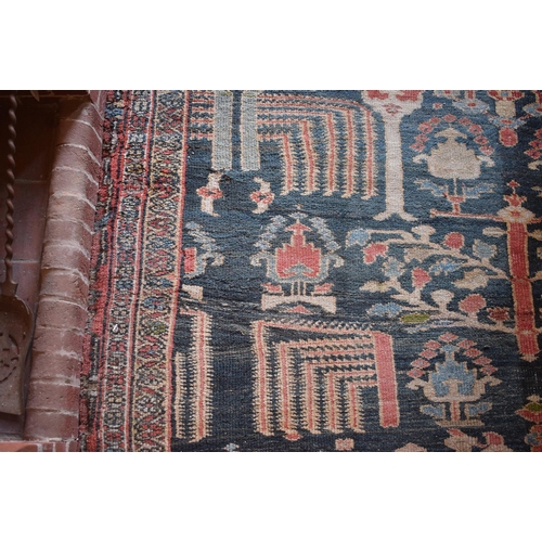 174 - A large carpet, with floral and geometric motifs on a blue ground, within a multi border, worn, fade... 