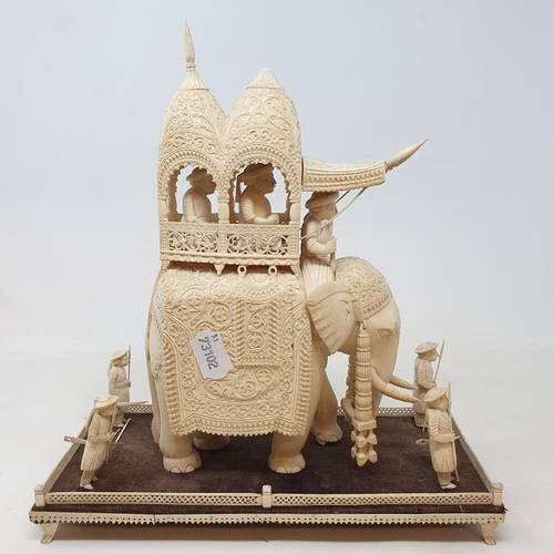 295 - A late 19th century carved ivory elephant, carrying a howdah, carrying two figures escorted by four ... 