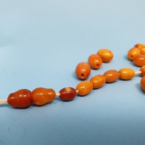 253 - A group of amber beads, removal cost A