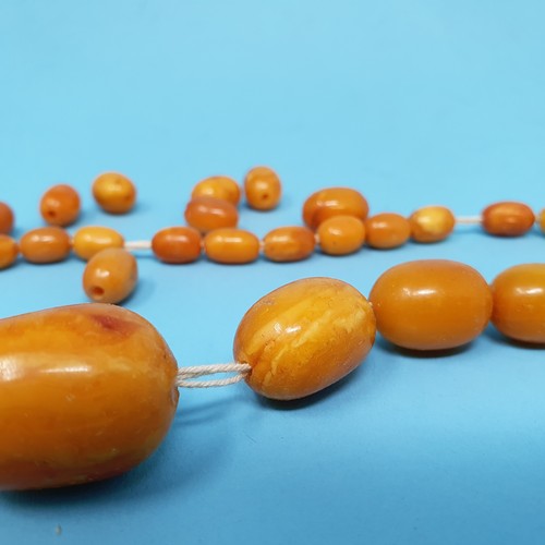 253 - A group of amber beads, removal cost A