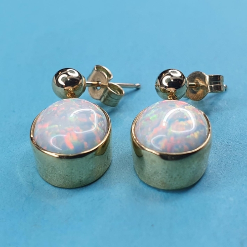 233 - A modern pair of of yellow metal and opal drop earrings