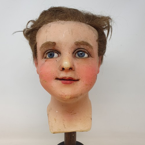 650 - A 19th century wax head, with glass eyes, on an ebonised stand, 40 cm high