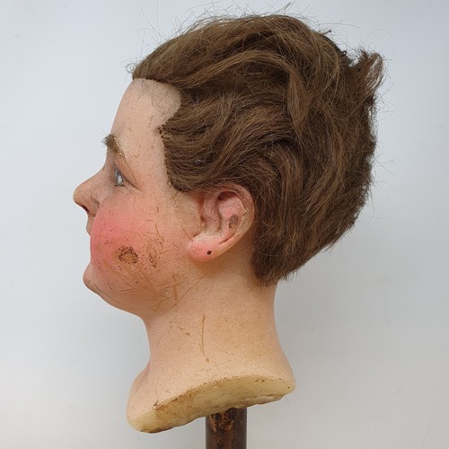 650 - A 19th century wax head, with glass eyes, on an ebonised stand, 40 cm high
