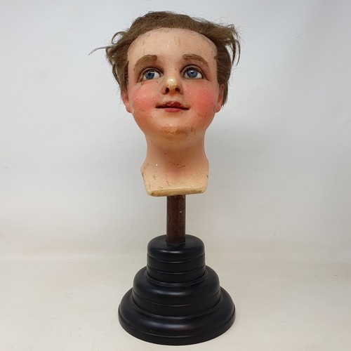 650 - A 19th century wax head, with glass eyes, on an ebonised stand, 40 cm high