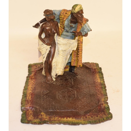 659 - A modern painted bronze figure of a trader, standing on a rug, 16 cm high
