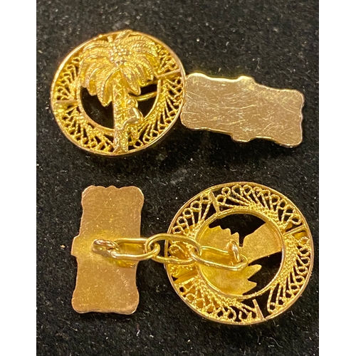 198 - A pair of yellow coloured metal cufflinks, decorated palm trees