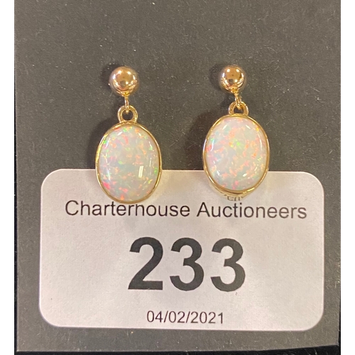 233 - A modern pair of of yellow metal and opal drop earrings