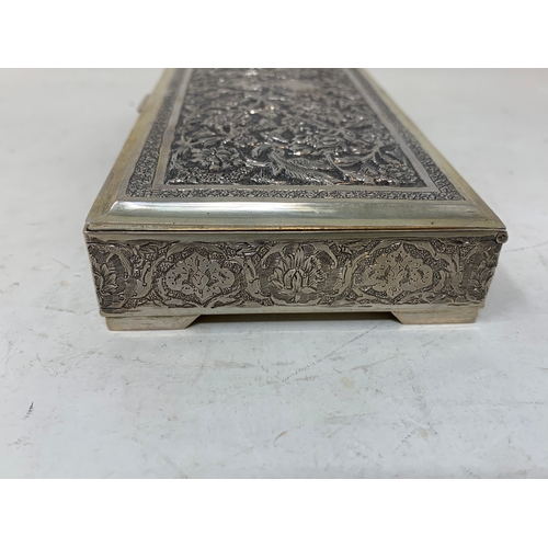 29 - A Persian silver coloured metal table cigarette box, decorated birds, flowers and foliage, 16 cm wid... 