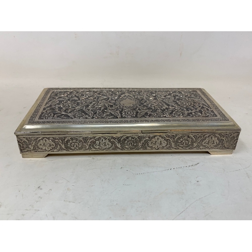 29 - A Persian silver coloured metal table cigarette box, decorated birds, flowers and foliage, 16 cm wid... 