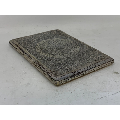 31 - A Persian silver coloured metal cigarette case, decorated birds, flowers and foliage, 11.5 cm wide