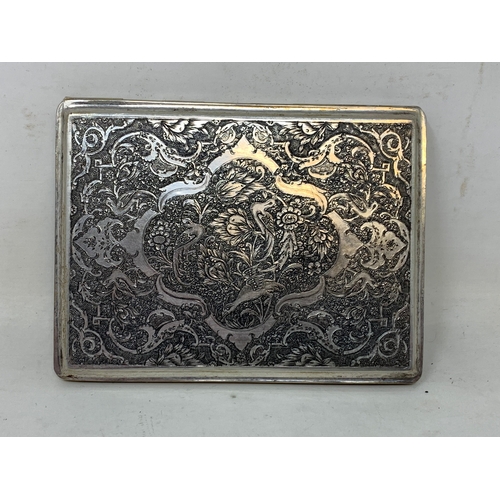 32 - A Persian silver coloured metal cigarette case, decorated birds, flowers and foliage, 10.5 cm wide