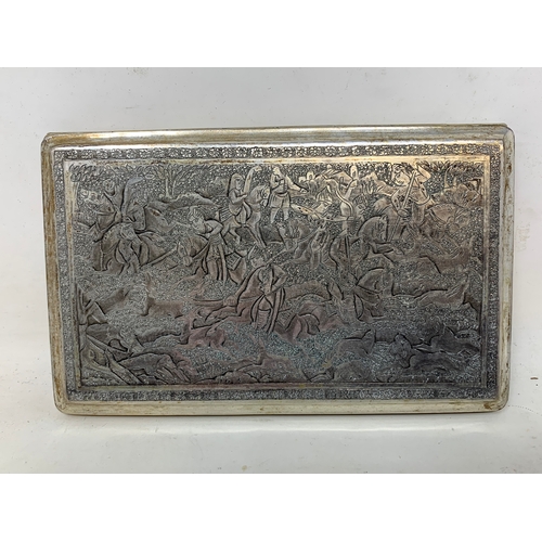 33 - A Persian silver coloured metal cigarette case, decorated figures on horseback hunting lions and oth... 