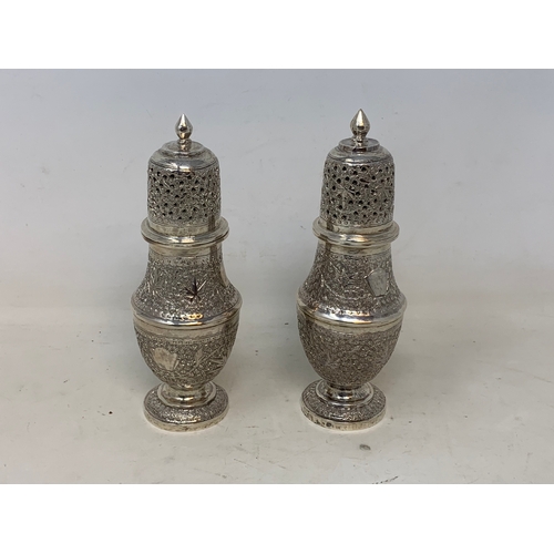 35 - A pair of Burmese style silver coloured metal sugar casters, 15.5 cm high (2)