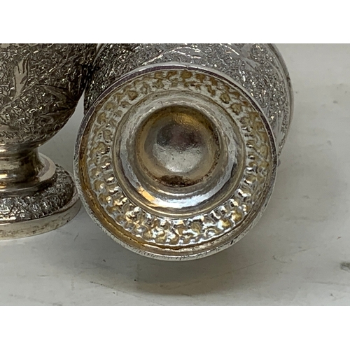 35 - A pair of Burmese style silver coloured metal sugar casters, 15.5 cm high (2)