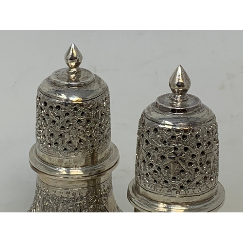 35 - A pair of Burmese style silver coloured metal sugar casters, 15.5 cm high (2)