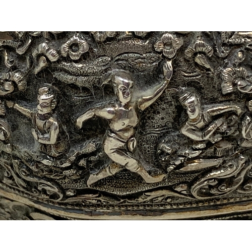 36 - A Burmese style silver coloured metal bowl, embossed figures and foliage, dented and holed, 13 cm di... 