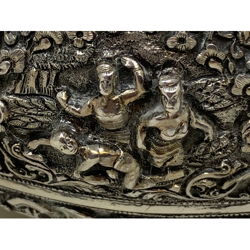 36 - A Burmese style silver coloured metal bowl, embossed figures and foliage, dented and holed, 13 cm di... 