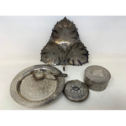 37 - A Malaysian style silver coloured metal leaf shaped dish, 19 cm wide, a similar silver coloured meta... 